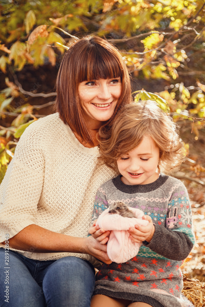 Mom and her daughters are being held by a little hedgehog Mom and her daughters are being held by a little hedgehog