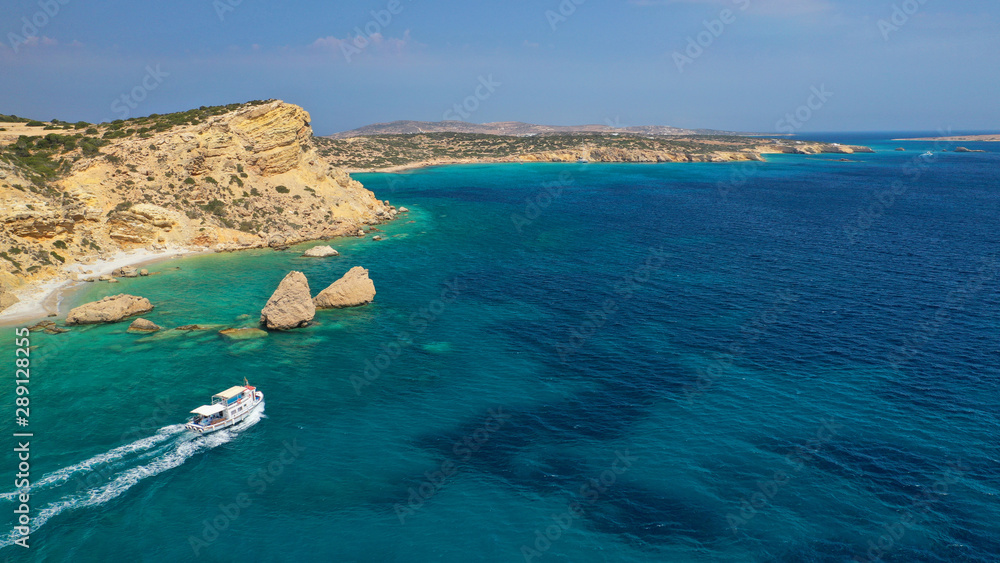 Aerial drone photo of picturesque and traditional tourist vessel cruising in famous beaches of Koufonisi island, Small Cyclades, Greece