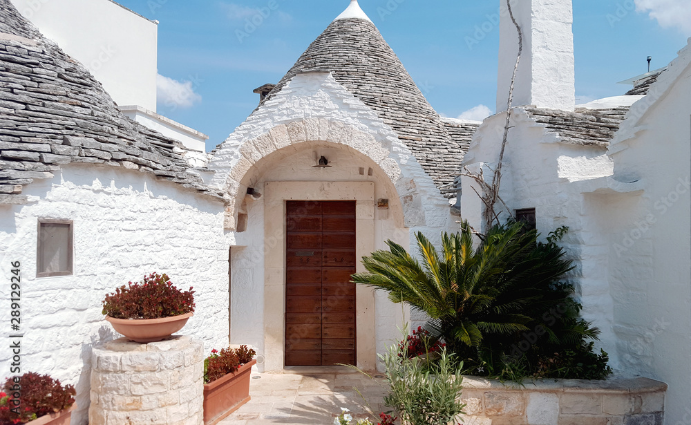 Old town village Alberobello in Bari, Italy with white pointy houses during summer.