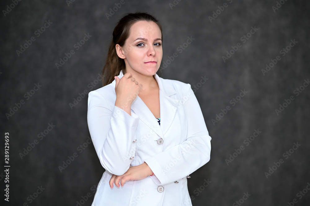 Business Portrait of a pretty female manager on a gray background in a white business suit. Standing right in front of the camera in various poses. Business Portrait of a pretty female manager on a gray background in a white business suit. Standing right in front of the camera in various poses.