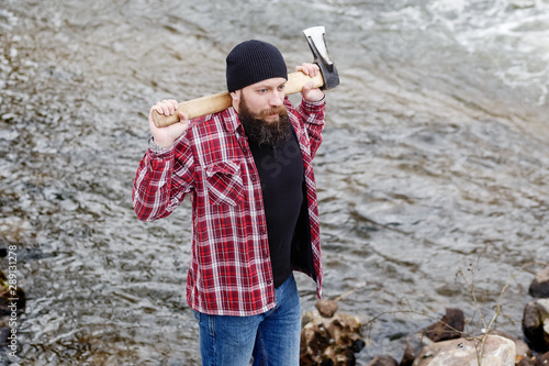 Fototapeta Naklejka Na Ścianę i Meble -  angry bearded man with an ax goes through the winter forest