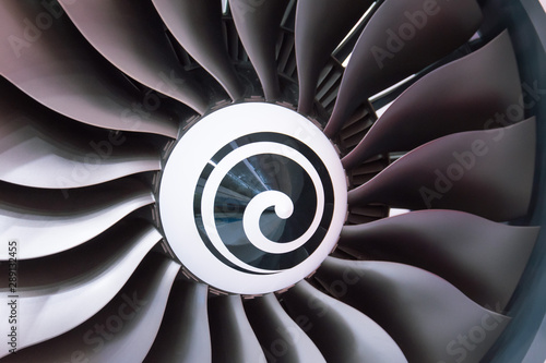 Close up of a turbofan turbine blades jet engine in modern airplane warm shade light.