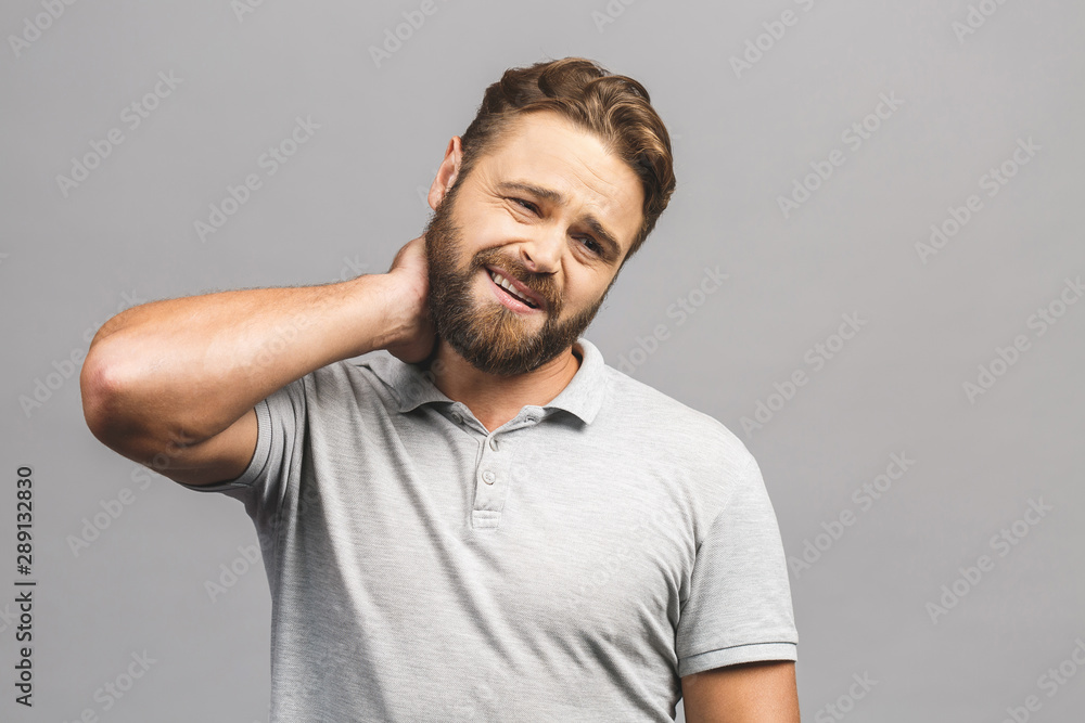 Pain in the neck. Man with backache. Muscular male body. Isolated on grey background Pain in the neck. Man with backache. Muscular male body. Isolated on grey background