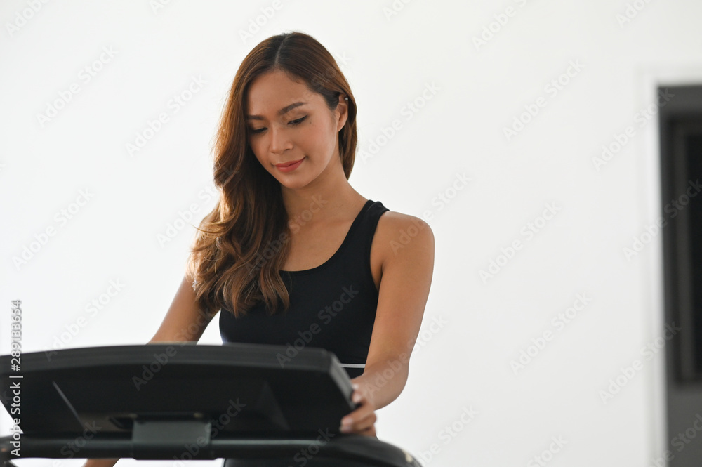 Sporty female stand on exercise bike machine cardio in fitness gym. Sporty female stand on exercise bike machine cardio in fitness gym.
