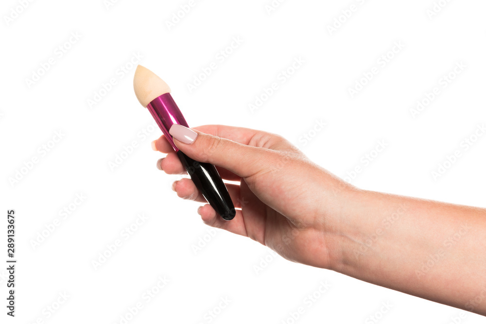 Cosmetic brush for makeup in a female hand isolated on white background. Cosmetic brush for makeup in a female hand isolated on white background.