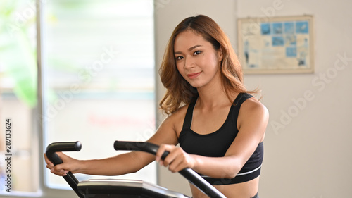 Sporty woman portrait and workout on exercise bike cardio in fitness gym. Free Download Sporty woman portrait and workout on exercise bike cardio in fitness gym. - GFXLoad