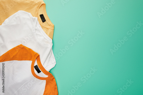 Schilderij op canvas top view of folded color t-shirts on turquoise background