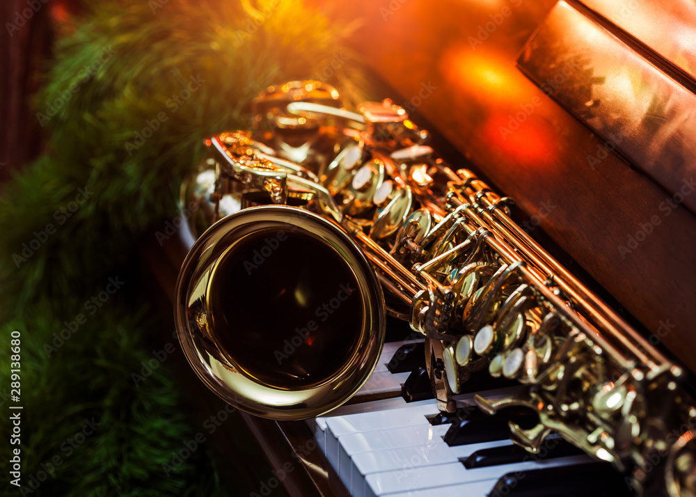 close up of alto saxophone on the Piano Keys with Christmas tree and  decoration light, in the night of Christmas season, Christmas background  Photos | Adobe Stock