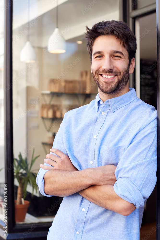 Fototapeta premium Portrait Of Male Owner Standing Outside Coffee Shop