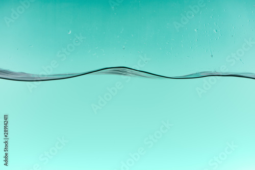 wavy clear water on turquoise background with drops