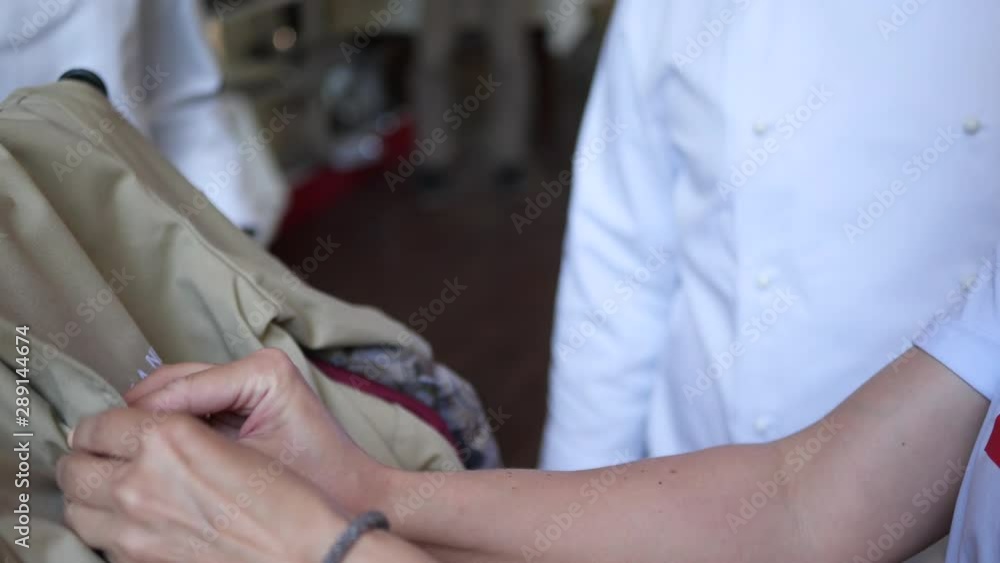 Woman demonstrates a chef's jacket buttoning buttons. Woman demonstrates a chef's jacket buttoning buttons.