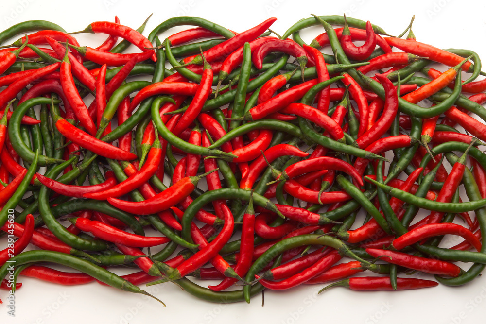 Pile of red & green long thin Chillies against white