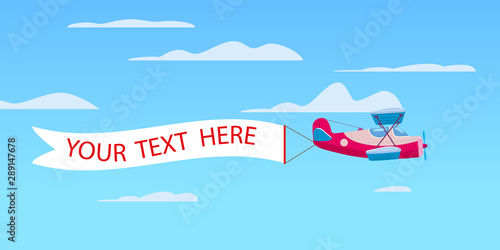 Red retro biplane aircraft pulling advertisement banner