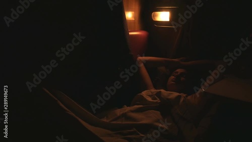Bad dream girl sleep in train. Night time international trip, dark outdoors and few lights seen outside. Very dark in a train car.