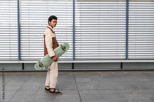 Skateboarder on background of window with rolettes photo