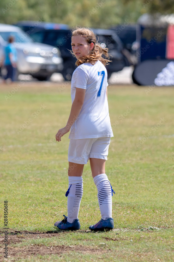 Young girl athlete playing soccer on a hot day Young girl athlete playing soccer on a hot day