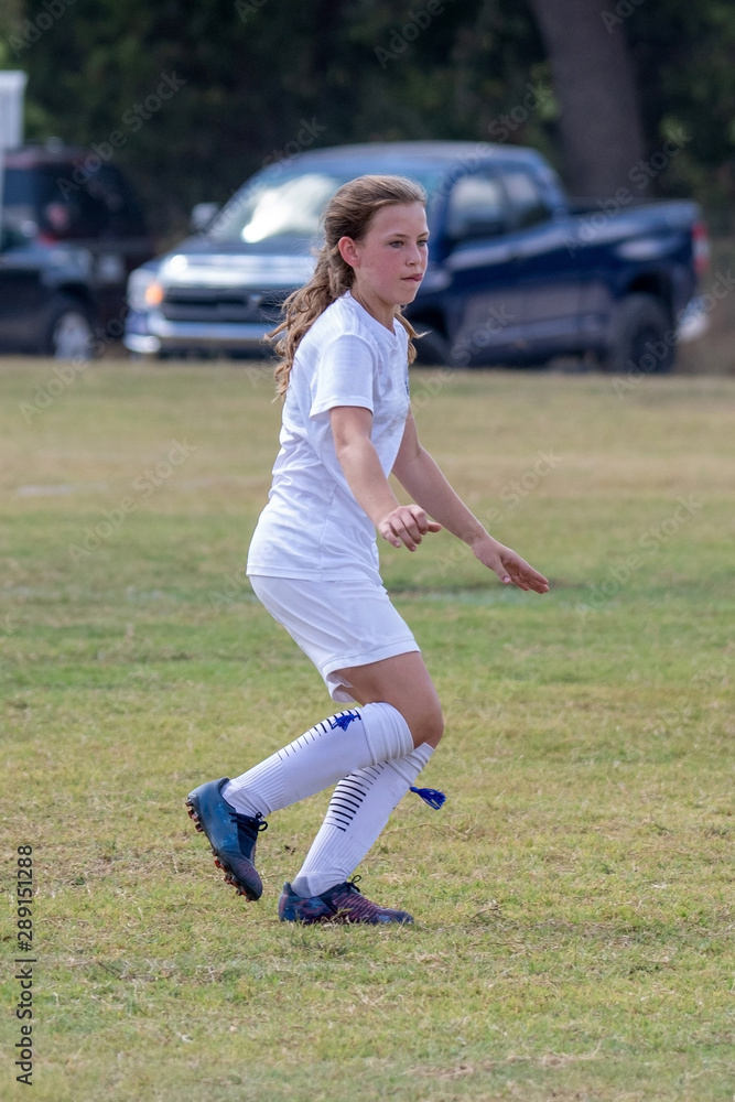Young girl athlete playing soccer on a hot day Young girl athlete playing soccer on a hot day