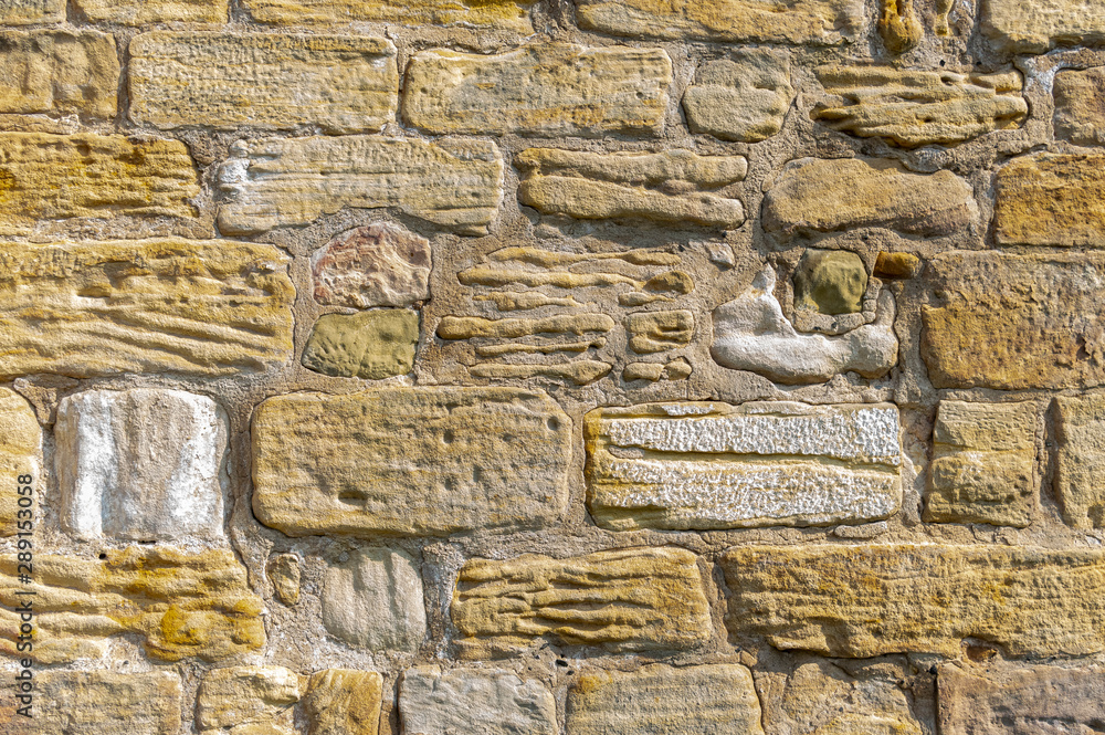Alte idyllische und schön gepflegte Sandsteinmauer aus gelbem Sandstein
