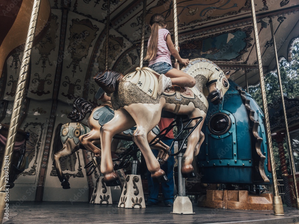French carousel. A girl is sitting on a horse.