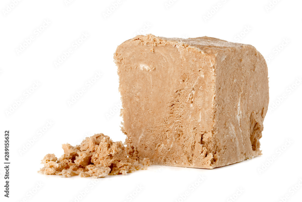 Halva on a white background. Arabian sweetness of caramel mass and ground roasted kernels of nuts, peanuts, close-up. Halva on a white background. Arabian sweetness of caramel mass and ground roasted kernels of nuts, peanuts, close-up.