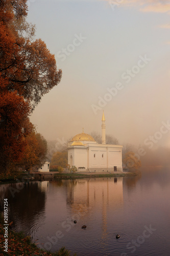 Russia, St. Petersburg, October 17, 2018, Catherine Park. In the photo, Turkish Bath in Tsarskoye Selo against the backdrop of an autumn park with red leaves and reflection in the lake in heavy fog