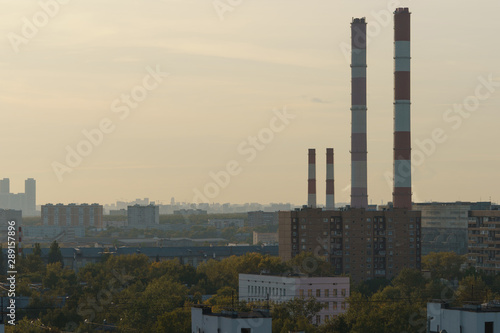 Photography of the sleeping area of Moscow in the red sunset. View from above / top view. Chimneys of Heat station. Lifestyle of big city in summer time.
