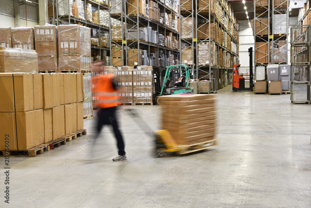warehouse worker in a forwarding agency - interior with forklift - transport and storage of goods warehouse worker in a forwarding agency - interior with forklift - transport and storage of goods