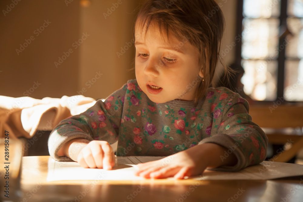 Learn аlways and everywhere concept. Cute little child girl reading a book. Learn аlways and everywhere concept. Cute little child girl reading a book.