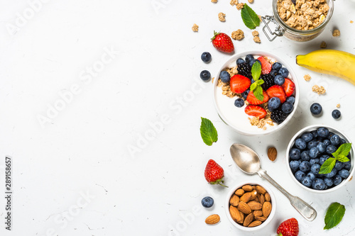 Greek yogurt granola with fresh berries on white table.