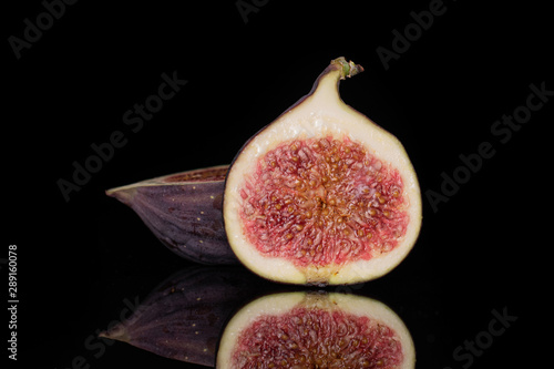 Group of two halves of fresh fig fruit isolated on black glass photo