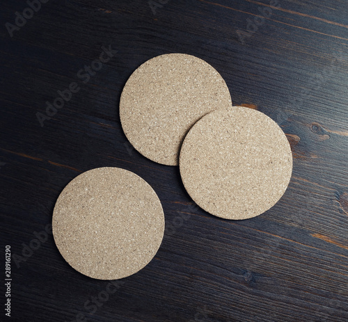 Photo of blank cork beer coasters on wooden background. Flat lay.