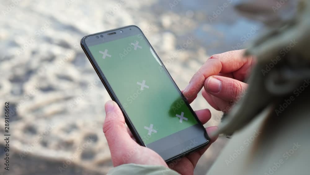Close-up. Green screen. A man holds a phone in his hands and scrolls the results of a search engine with his finger. Close-up. Green screen. A man holds a phone in his hands and scrolls the results of a search engine with his finger.