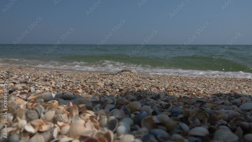 Sea wave on the sandy shore of the Black Sea. A woman runs through the sand. Slow motion Sea wave on the sandy shore of the Black Sea. A woman runs through the sand. Slow motion