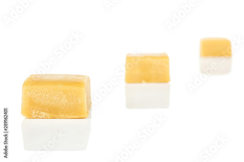 Group of three whole sweet golden caramel candy isolated on white background