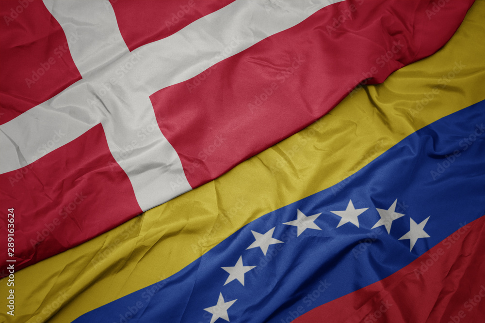 waving colorful flag of venezuela and national flag of denmark.