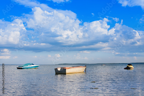Fototapeta Naklejka Na Ścianę i Meble -  Summer lake and boats. Dramatic sky with clouds. Belorussia