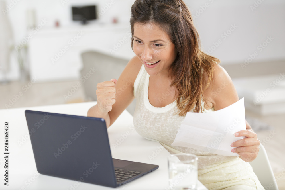 happy woman reading letter with good news sitting on sofa happy woman reading letter with good news sitting on sofa