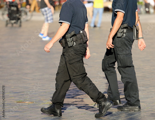 Canvas Print policeman in uniform and guns patrolling the city