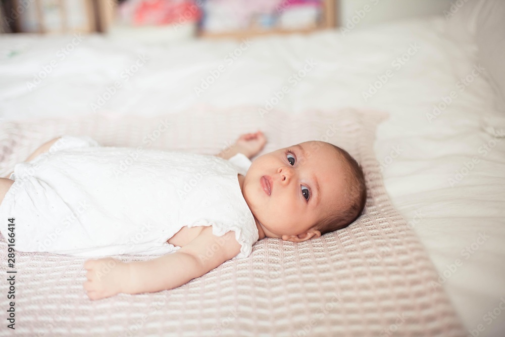 Little cute girl 3 months old is lying on the bed. Baby. Children bedroom. Little cute girl 3 months old is lying on the bed. Baby. Children bedroom.