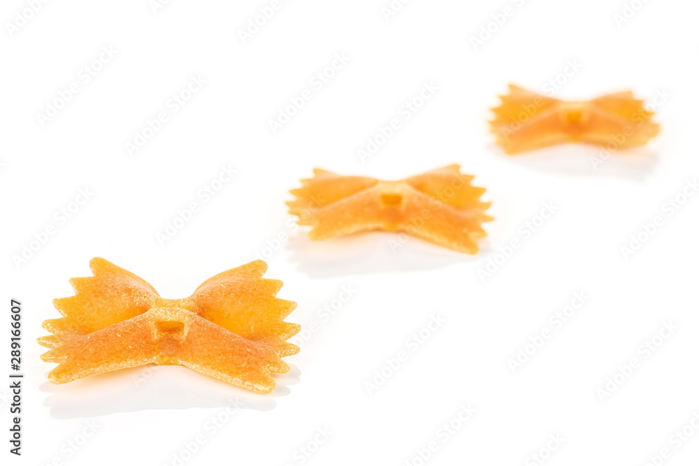 Fototapeta premium Group of three whole red uncooked farfalle isolated on white background