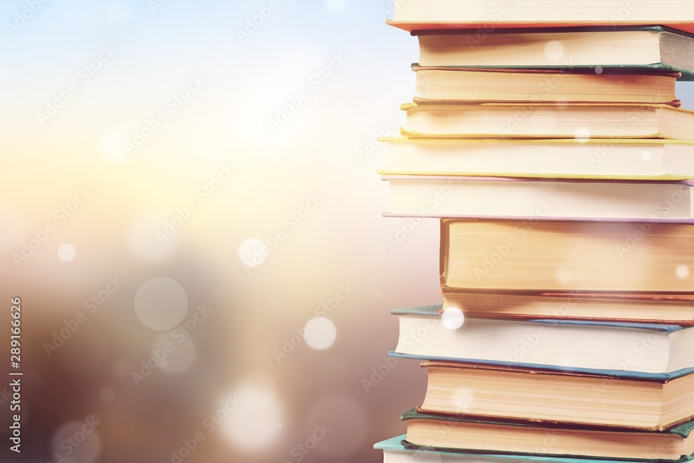 Stack of colorful books on blurred background - obrazy, fototapety, plakaty 