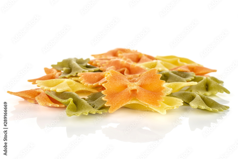 Lot of whole red, yellow and green uncooked farfalle isolated on white background