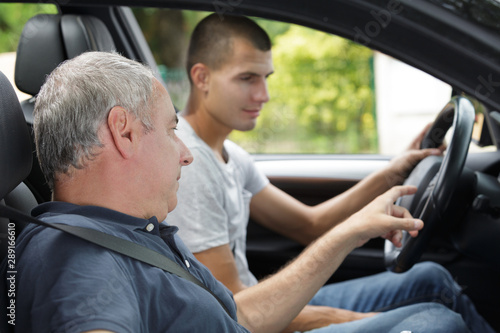father teaching teenage son to drive