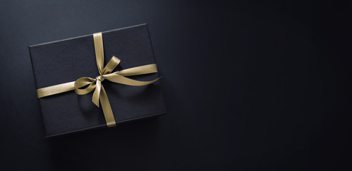 Gift wrapped in dark paper on dark background