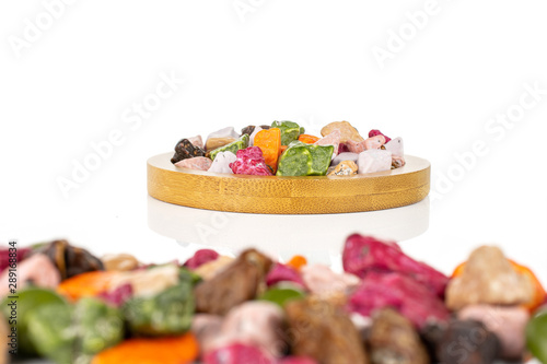 Lot of whole sweet chocolate stone on bamboo coaster isolated on white background