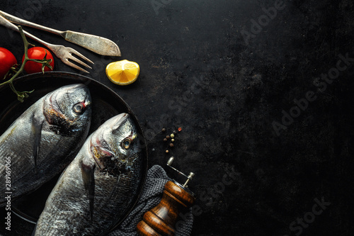 Fototapeta Naklejka Na Ścianę i Meble -  Dorado fish with ingredients on dark