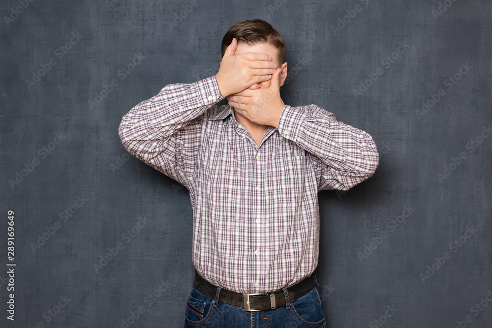 Studio shot of man covering eyes and mouth with hands Studio shot of man covering eyes and mouth with hands