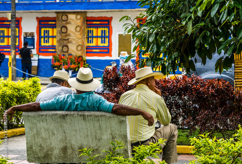 Fotografía People of Colombia, group of old man sitting on bench in the colorful streets of