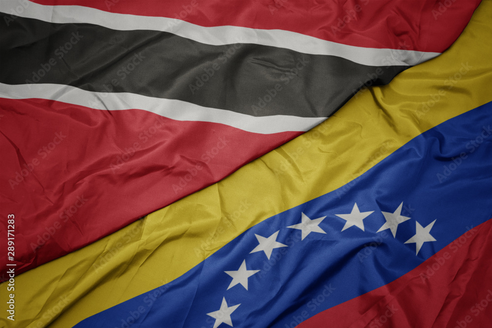 Fototapeta premium waving colorful flag of venezuela and national flag of trinidad and tobago.