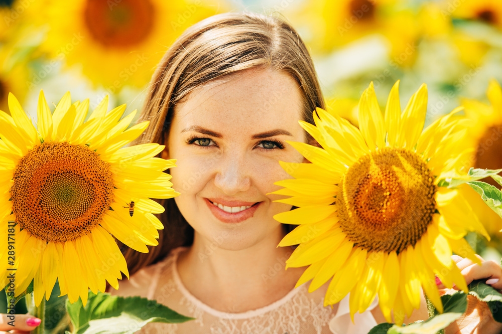 Outdoor portrait of beautiful young woman with sunflowers, health and lifestyle, girl hiding behind flowers Outdoor portrait of beautiful young woman with sunflowers, health and lifestyle, girl hiding behind flowers